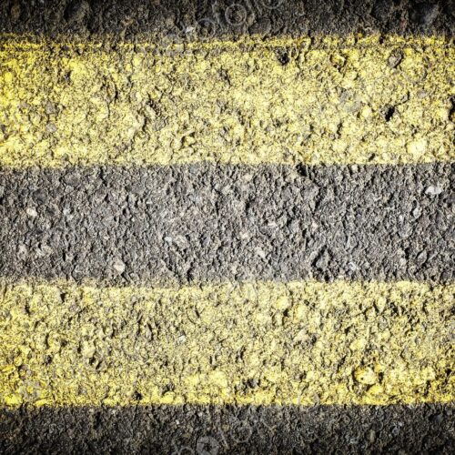 Extreme closeup of double yellow lines painted on the roadway Extreme closeup of double yellow lines painted on the roadway