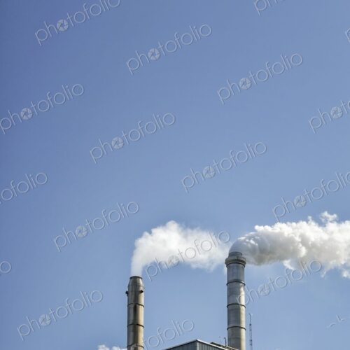 Factory smokestacks against a clear blue sky in Washington state.