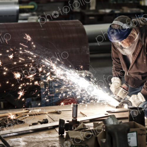 Factory worker grinding a steel edge in a sheet metal factory.