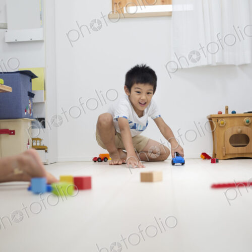 Family home. A boy playing with cars on the floor.