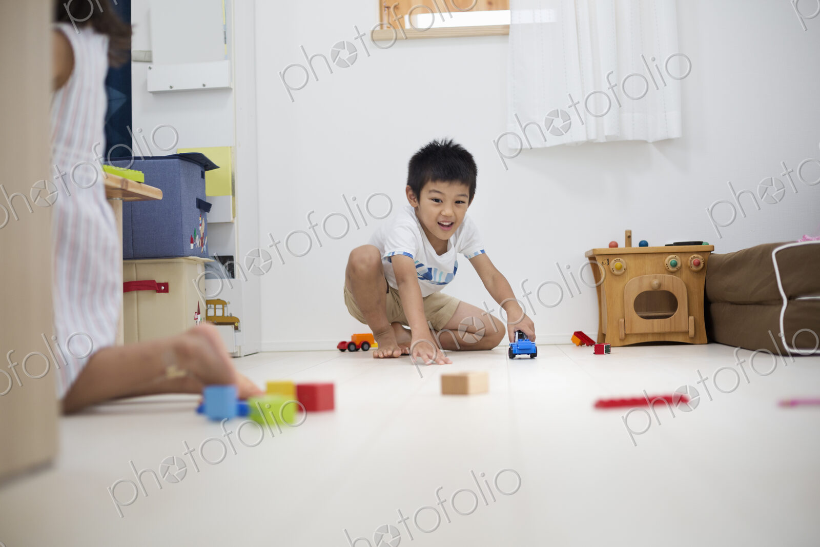 Family home. A boy playing with cars on the floor.
