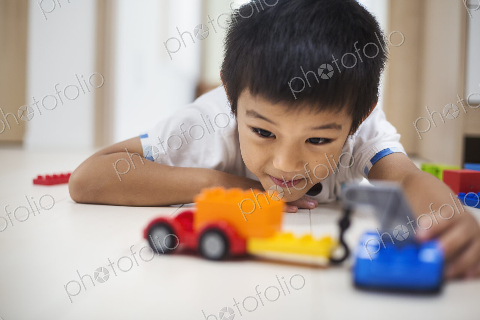 Family home. A boy playing with cars on the floor.