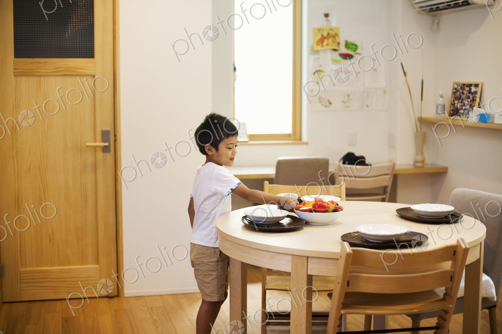 Family home. A boy setting the table for a meal.