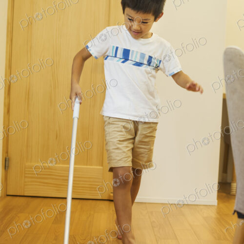 Family home. A boy with a mop cleaning a wooden floor.