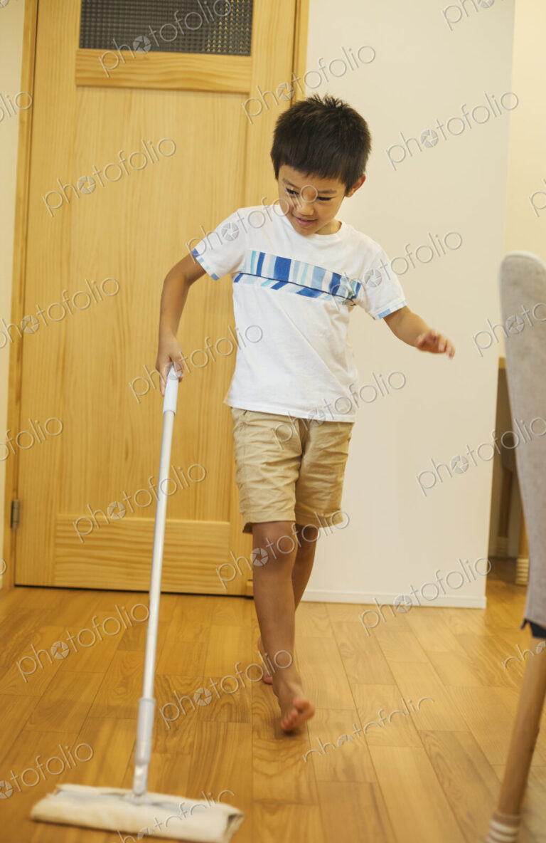 Family home. A boy with a mop cleaning a wooden floor.
