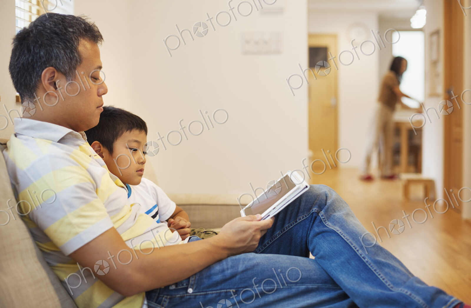 Family home. A man and his son sitting reading a book.
