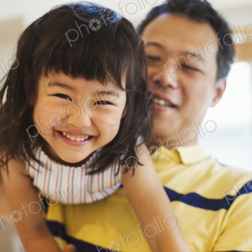 Family home. A man holding his young daughter.