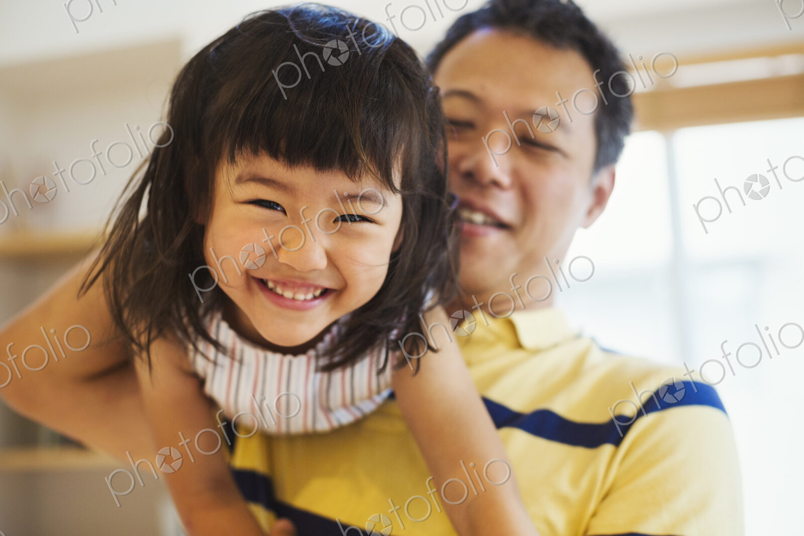 Family home. A man holding his young daughter.