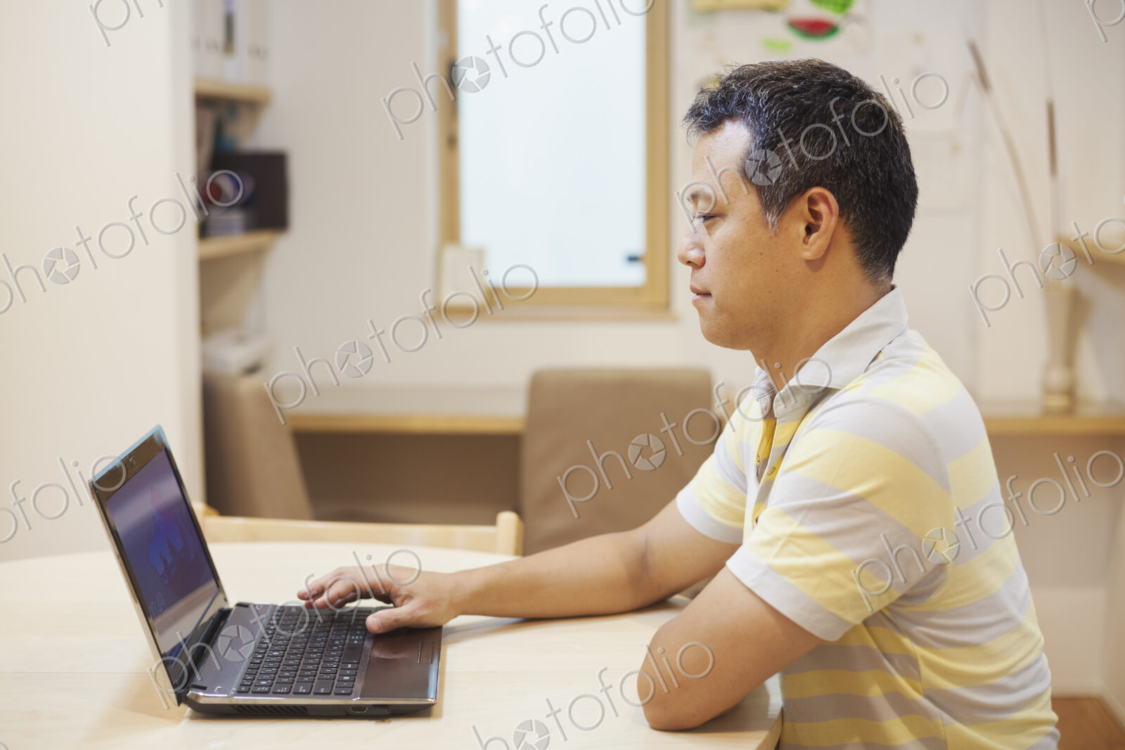 Family home. A man seated using a laptop.