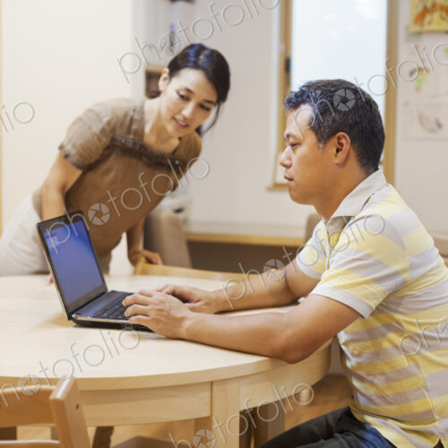 Family home. A man seated using a laptop. Family home. A man seated using a laptop.