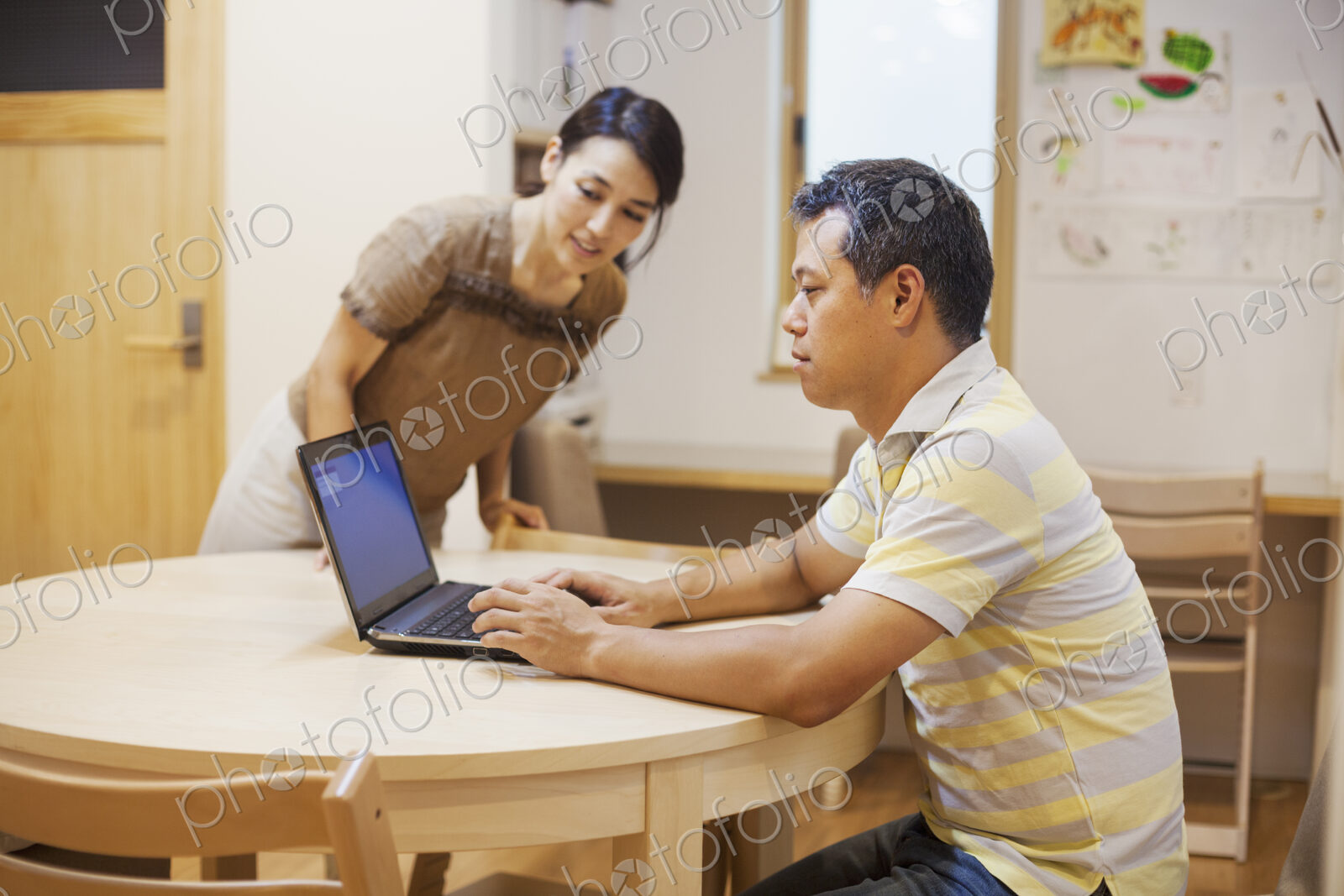 Family home. A man seated using a laptop.
