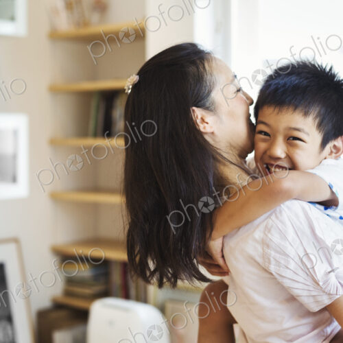 Family home. A mother and her son cuddling. Family home. A mother and her son cuddling.