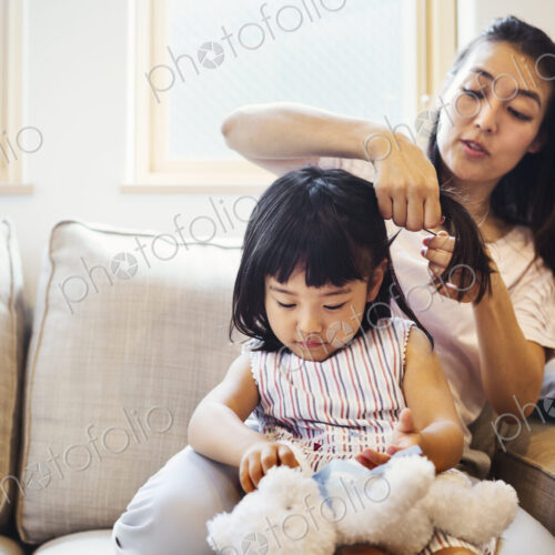 Family home. A mother combing her daughter's hair. Family home. A mother combing her daughter's hair.