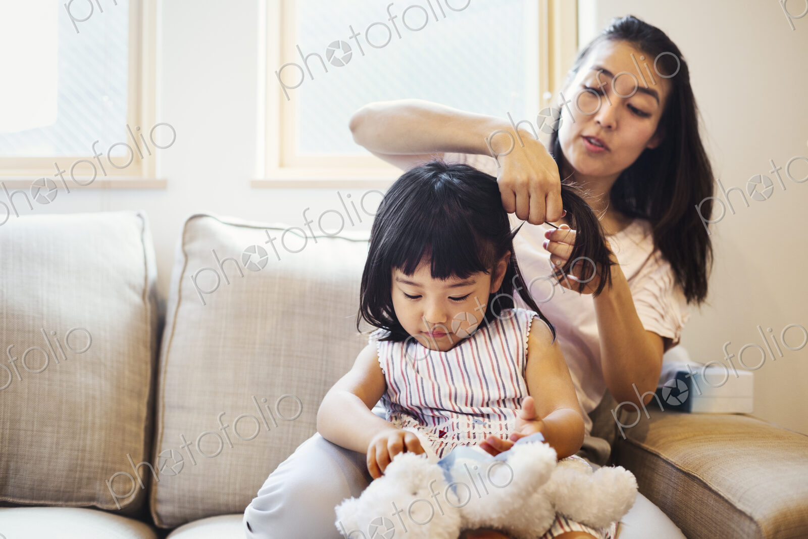 Family home. A mother combing her daughter’s hair.