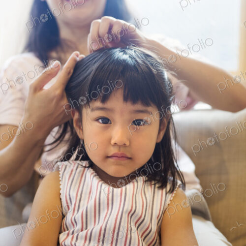 Family home. A mother combing her daughter's hair. Family home. A mother combing her daughter's hair.