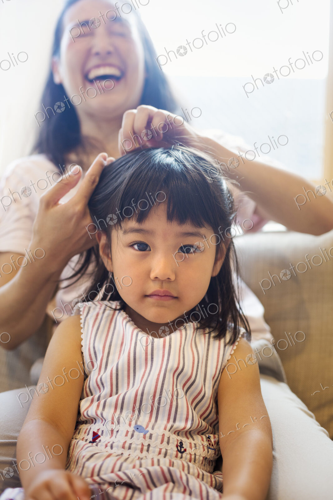 Family home. A mother combing her daughter’s hair.