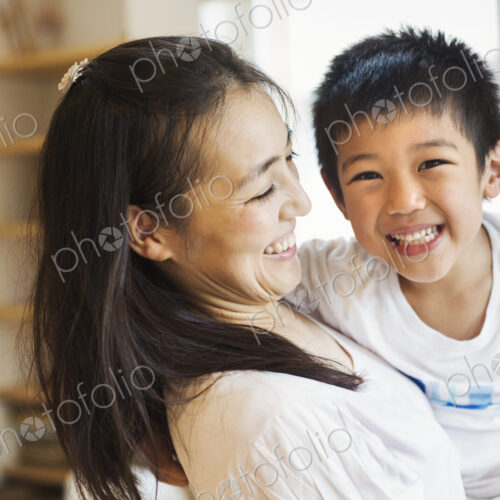 Family home. A mother holding her son, and a father holding his daughter. Family home. A mother holding her son, and a father holding his daughter.