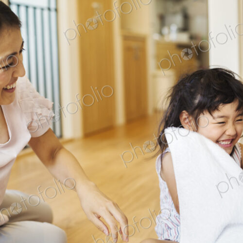 Family home. A woman and her daughter folding clean laundry.