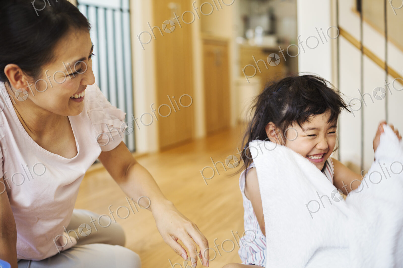 Family home. A woman and her daughter folding clean laundry.