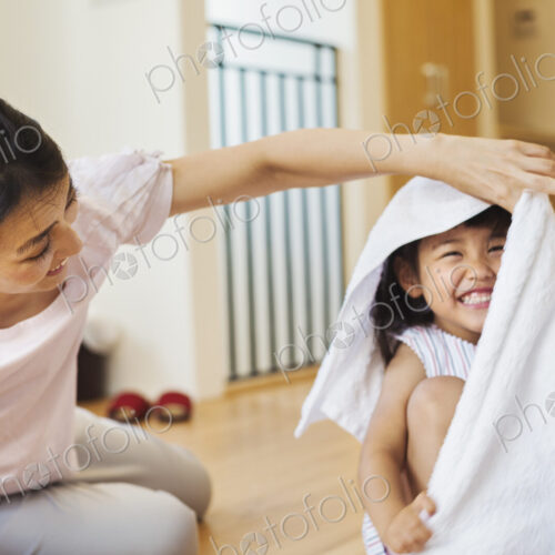 Family home. A woman and her daughter folding clean laundry.