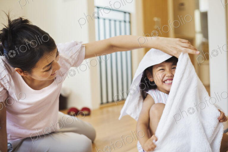 Family home. A woman and her daughter folding clean laundry.