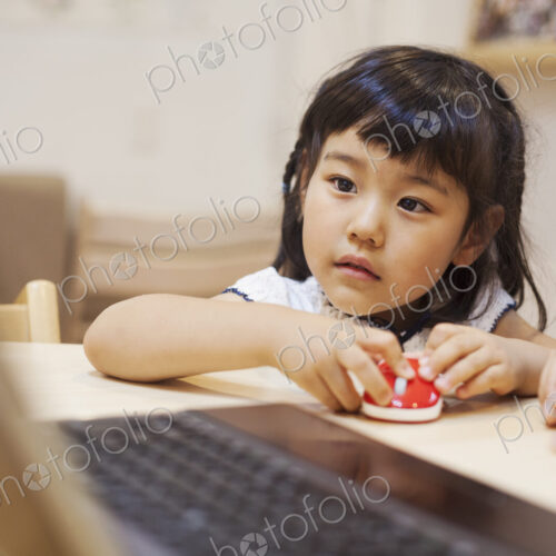 Family home. A woman and her daughter seated at a table looking at the screen of a laptop. Family home. A woman and her daughter seated at a table looking at the screen of a laptop.