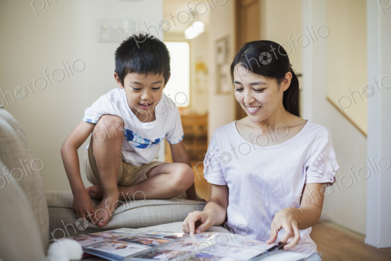 Family home. A woman and her son looking at a photographic album.