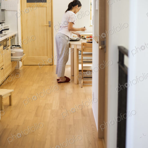 Family home. A woman standing in a kitchen. Family home. A woman standing in a kitchen.