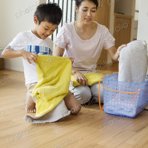 Family home. a woman and her son sorting and folding clean laundry.