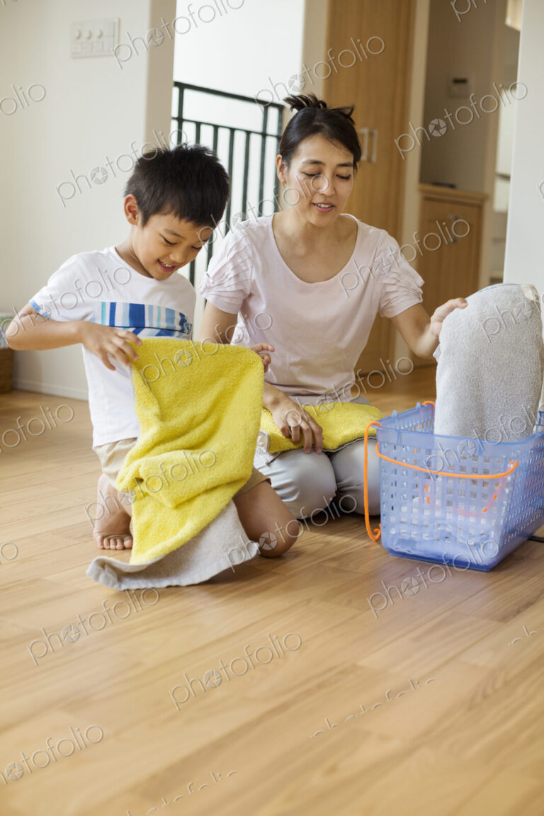 Family home. a woman and her son sorting and folding clean laundry.