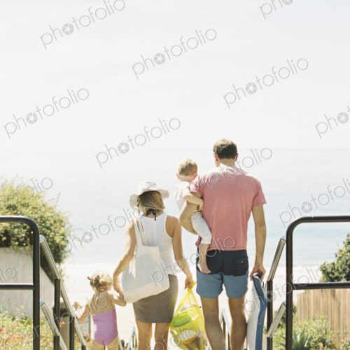 Family on a day out at a sandy beach by the ocean.