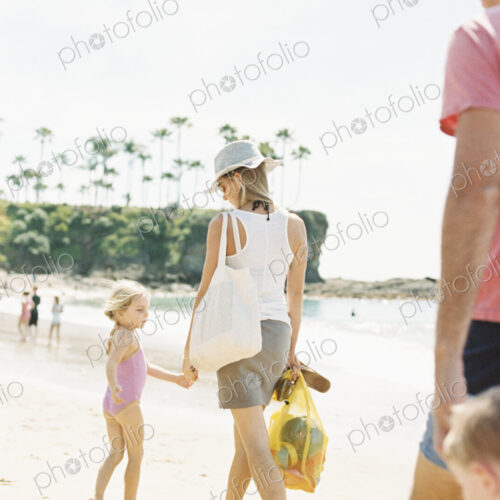 Family on a day out at a sandy beach by the ocean.