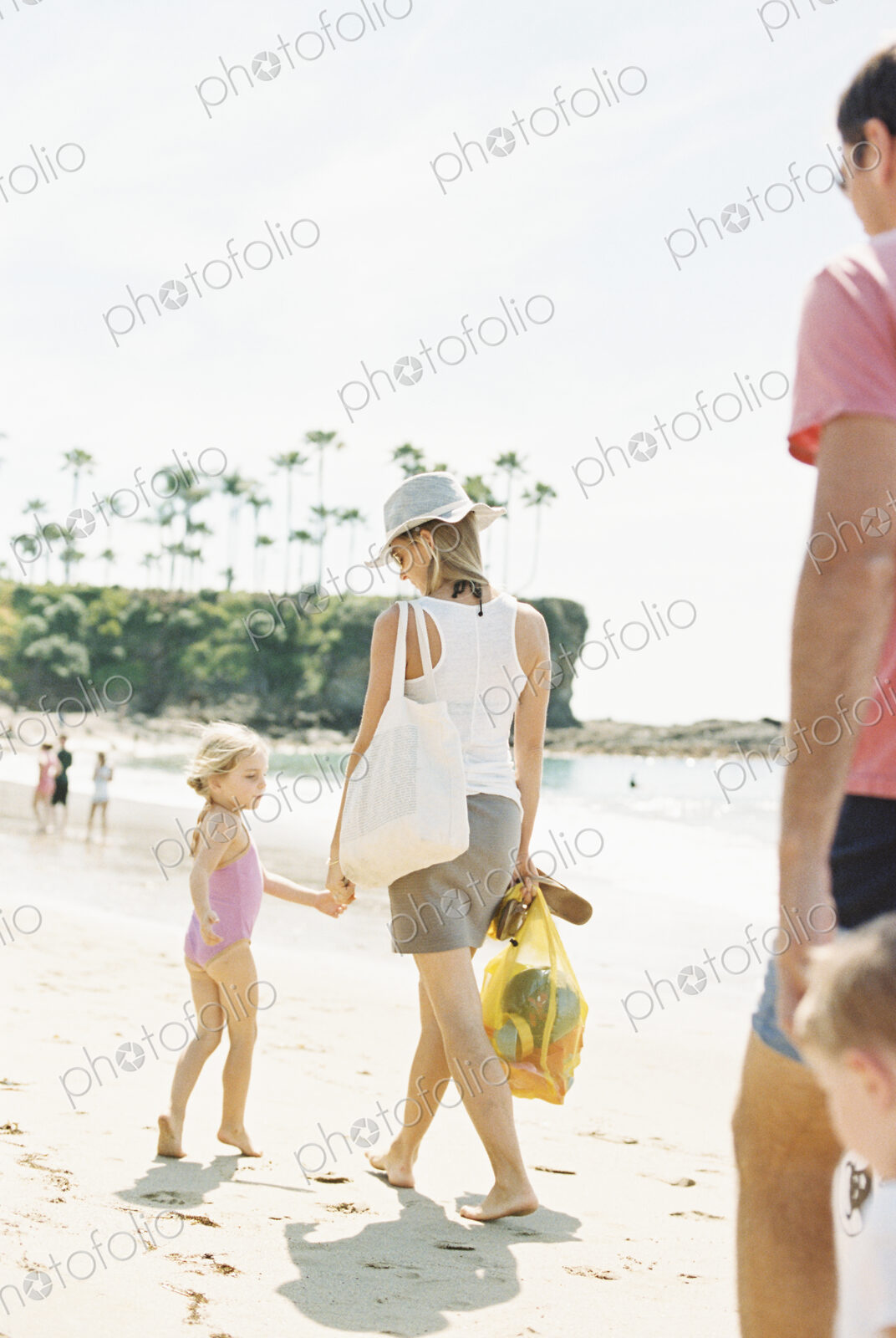 Family on a day out at a sandy beach by the ocean.