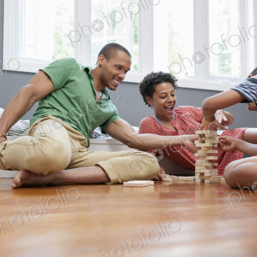 Family on the floor playing a game at home. Family on the floor playing a game at home.