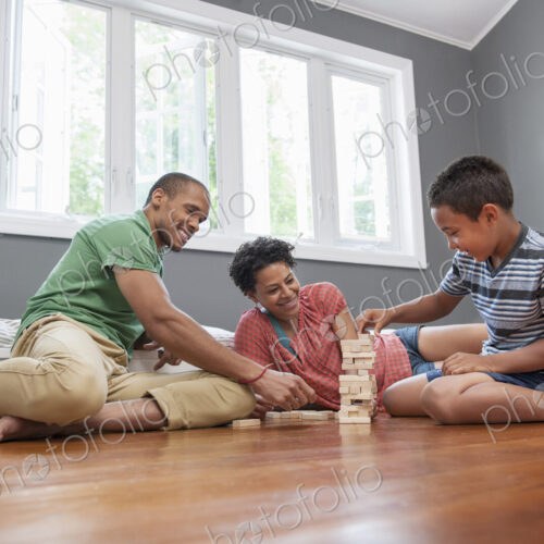 Family on the floor playing a game at home. Family on the floor playing a game at home.