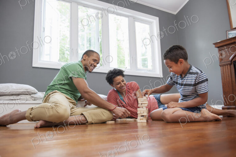 Family on the floor playing a game at home.