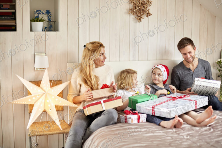 Family, two adults and two children on Christmas morning opening presents