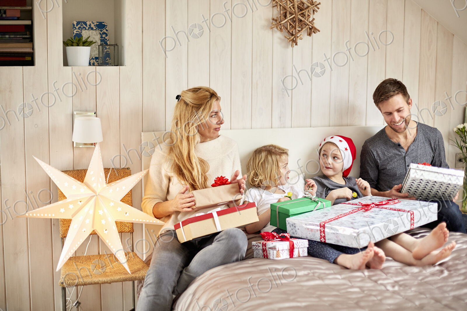 Family, two adults and two children on Christmas morning opening presents