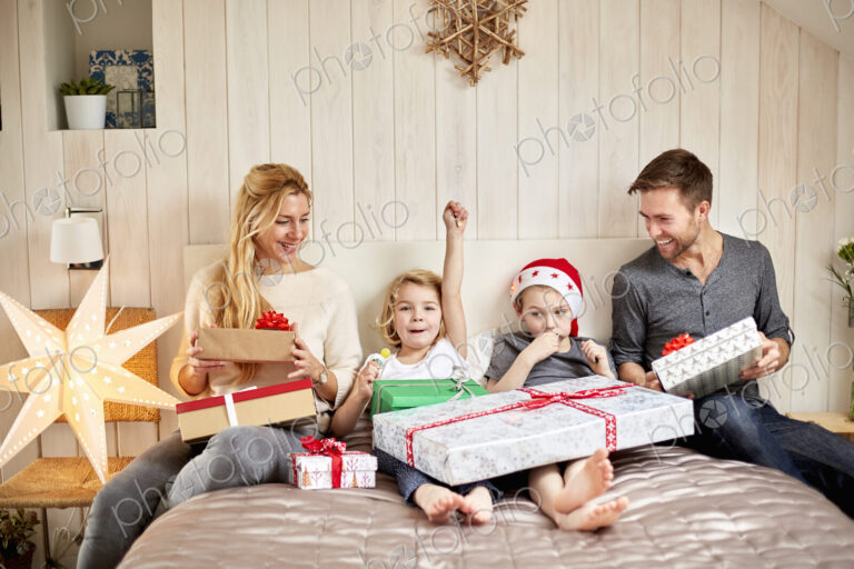 Family, two adults and two children on Christmas morning opening presents