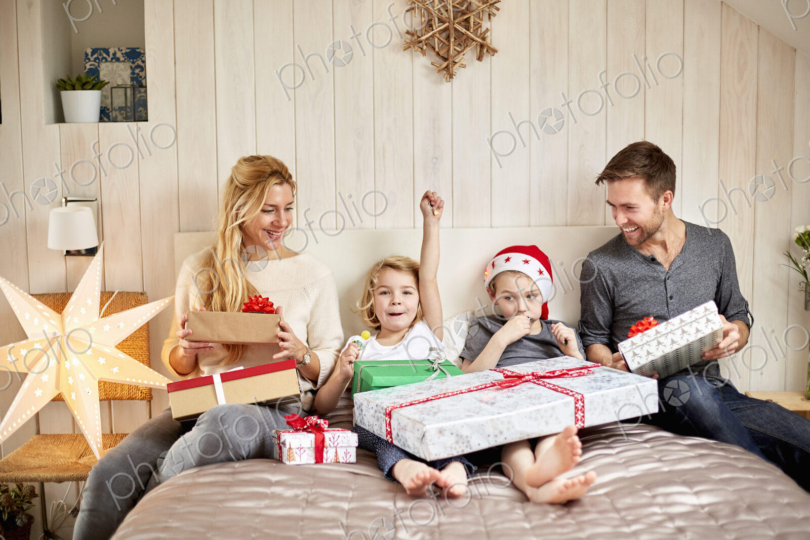 Family, two adults and two children on Christmas morning opening presents