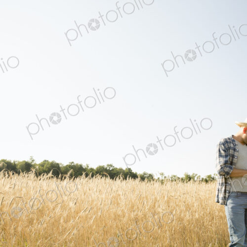 Farmer in jeans and straw hat, using a digital tablet