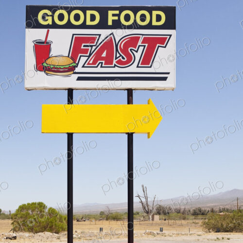 Fast food sign by the road, Good Food Fast and a yellow arrow.