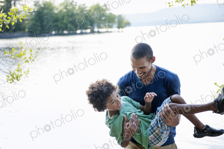 Father playing with his son carrying him in his arms.