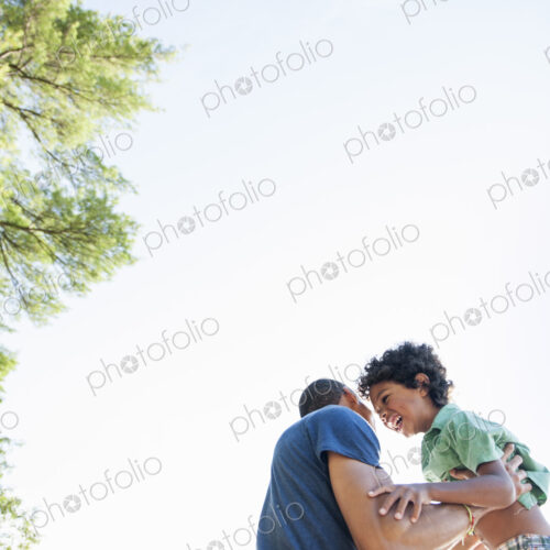 Father playing with his son, lifting the boy up in the air. Father playing with his son, lifting the boy up in the air.