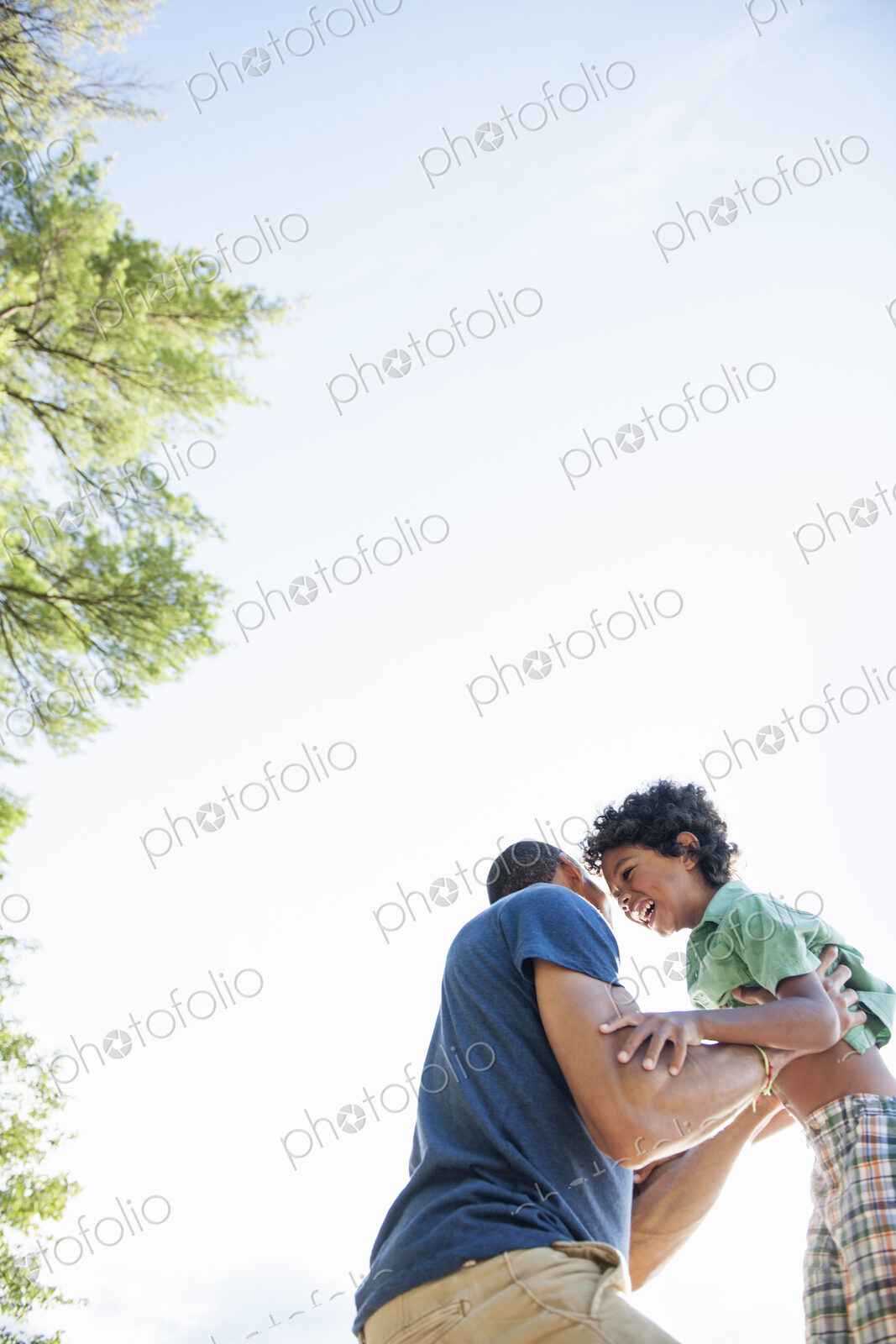 Father playing with his son, lifting the boy up in the air.