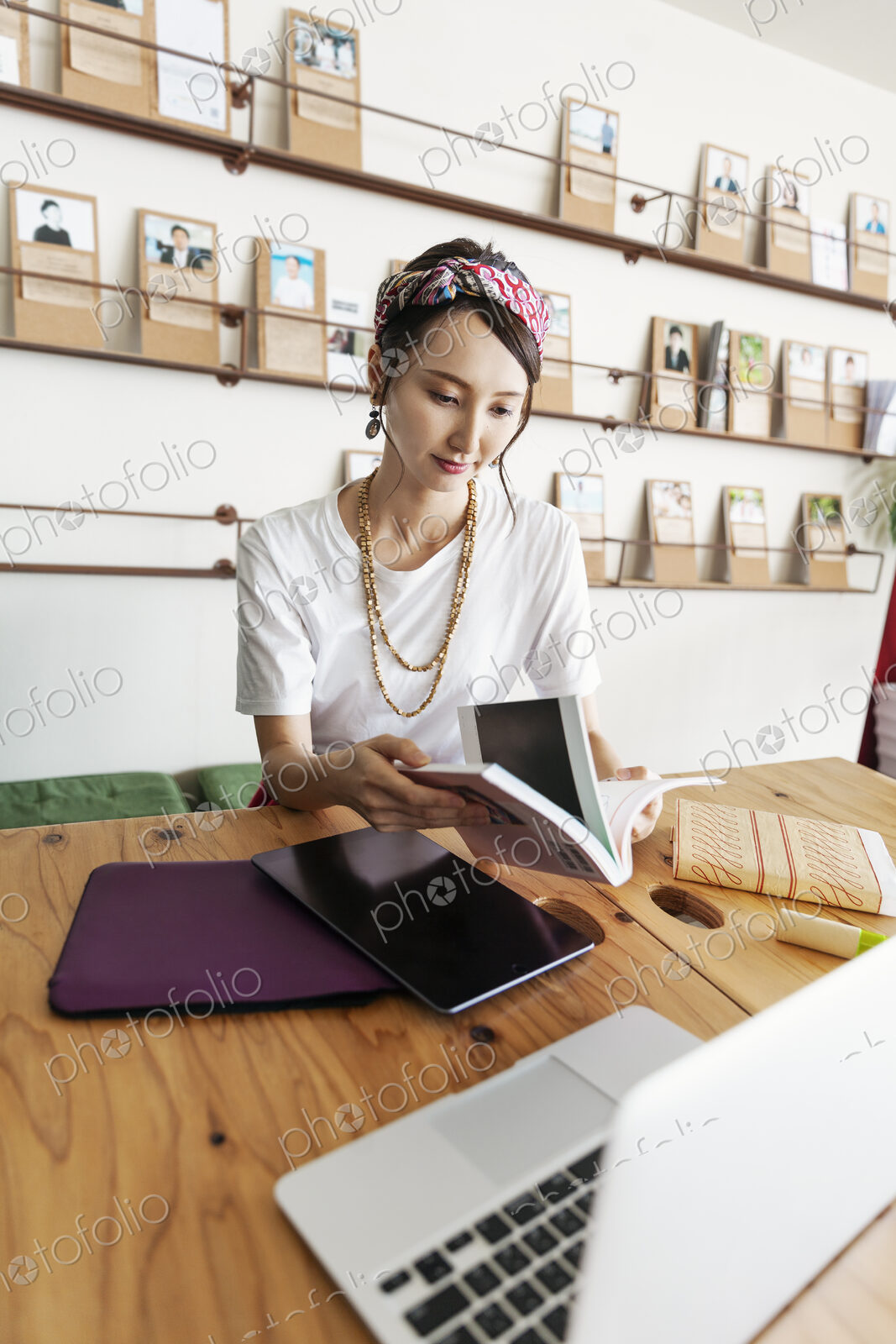 Female Japanese professional sitting at table in a co-working space, using digital…