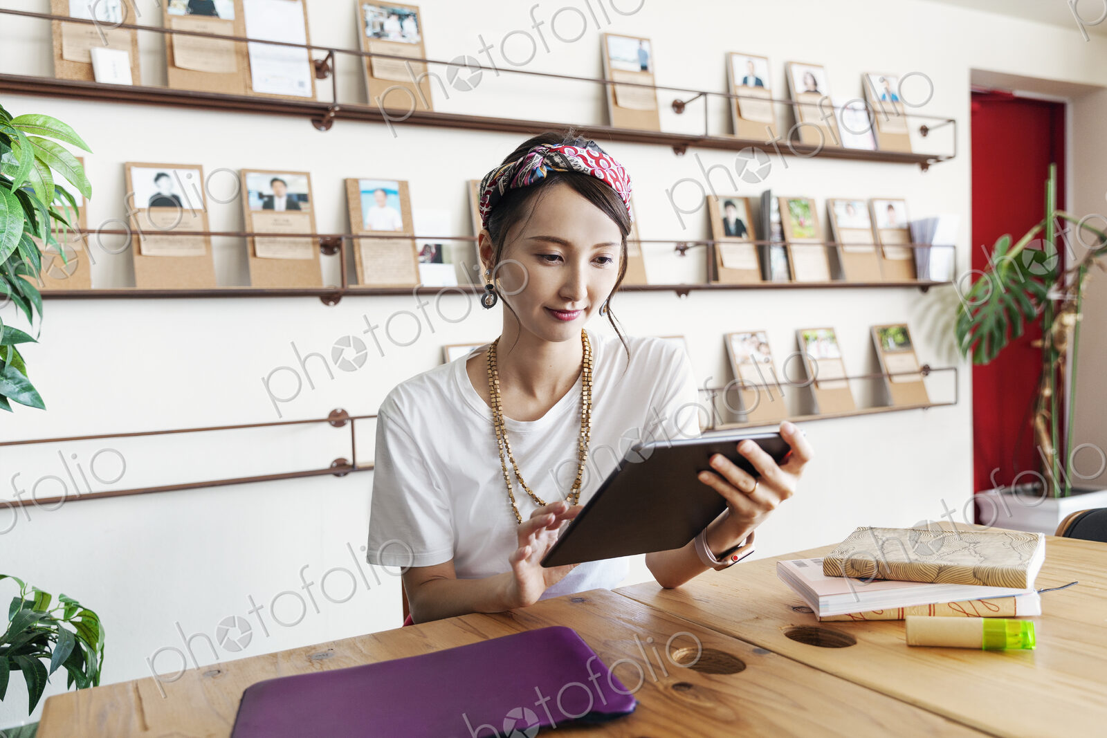 Female Japanese professional sitting at table in a co-working space, using digital…