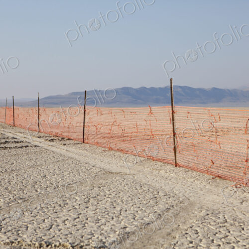 Fence barricade extending across the flat landscape, Black Rock Desert, Nevada.