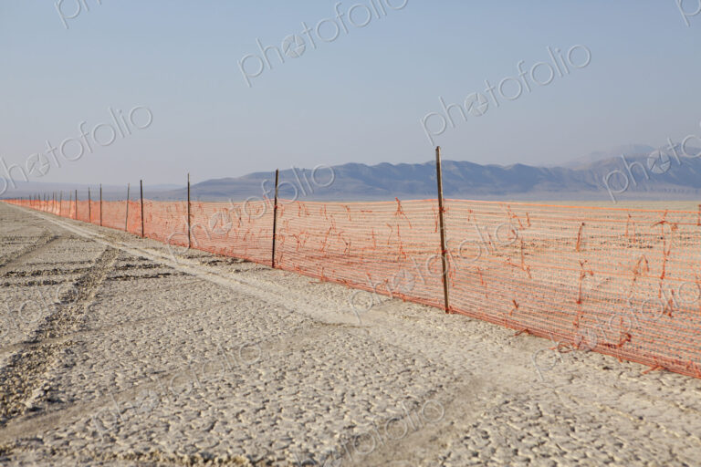 Fence barricade extending across the flat landscape, Black Rock Desert, Nevada.