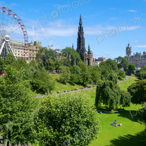 Ferris wheel and Scott monument in park in Edinburgh.